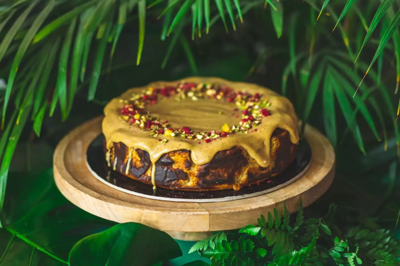 Sernik Pistacjowy udekorowany pistacjami, podany na eleganckim talerzu